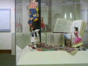 Traditional Embrodery (center) Small Greek Icon of the Virgin Mary (Eleousa, meaning tender touch) with Christ child (right) Books written in Greek (back) Evil Eye medallion and worry beads (right) ~Courtesy loan from Cornelia Paraskevas